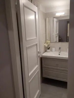 a bathroom with a white door and a sink at Fontana Di Trevi - Central Apartment in Rome in Rome