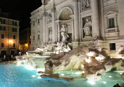 a large fountain in front of a building at night at Fontana Di Trevi - Central Apartment in Rome in Rome
