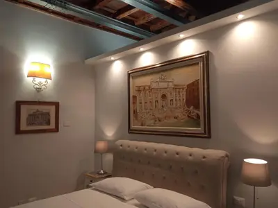 a bedroom with a bed with a picture on the wall at Fontana Di Trevi - Central Apartment in Rome in Rome