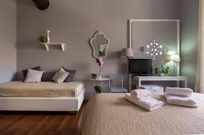 a bedroom with two beds and a tv and a mirror at Dulcis In Fundo b&b in Rome