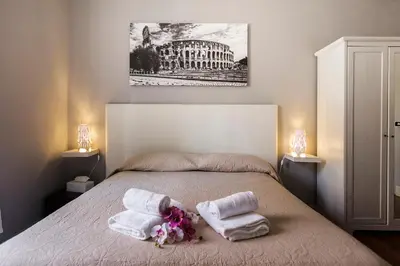 a bedroom with a bed with towels and two lamps at Dulcis In Fundo b&b in Rome