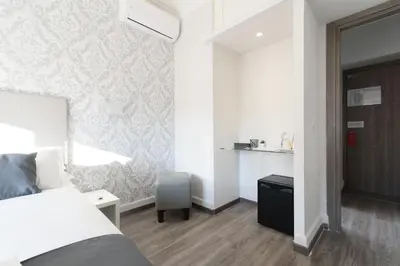 a bedroom with a bed and a desk with a chair at White Caesar Guesthouse in Rome