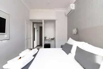 a bedroom with a white bed with white pillows at White Caesar Guesthouse in Rome