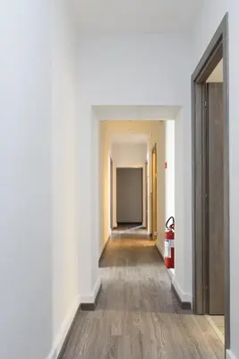 an empty hallway with white walls and wooden floors at White Caesar Guesthouse in Rome