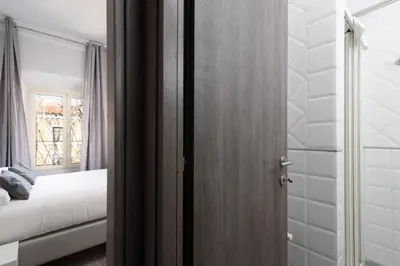 a door to a bedroom with a bed and a window at White Caesar Guesthouse in Rome