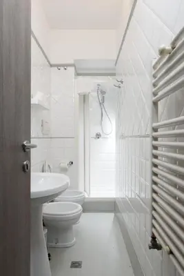 a white bathroom with a toilet and a sink at White Caesar Guesthouse in Rome