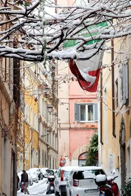 a street with cars and a flag hanging from buildings at Casa Veniero in Rome