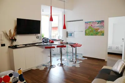 a bedroom with a red bed with slippers on it at Casa Veniero in Rome