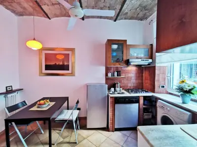 a kitchen with a table and a refrigerator at Borgo Pio San Pietro Apartment in Rome