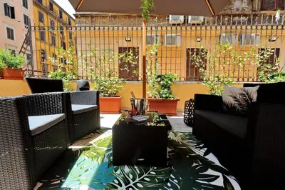 a patio with wicker chairs and tables and plants at Termini Terrace in Rome