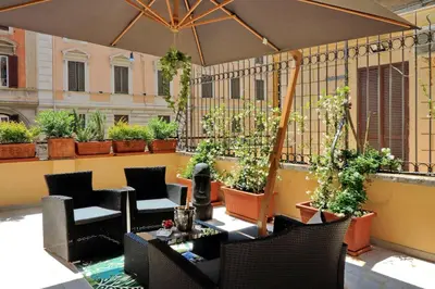 an outdoor patio with chairs and tables and plants at Termini Terrace in Rome