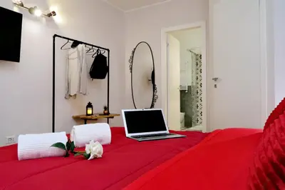 a laptop computer sitting on top of a red bed at Termini Terrace in Rome