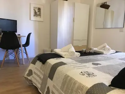a bedroom with a bed and a table and a television at LE FATE SUITES in Rome