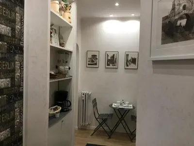 a room with a table with a chair and pictures on the wall at LE FATE SUITES in Rome
