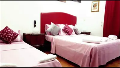 a bedroom with two beds with pink and white sheets at affittacamere sereno in Rome