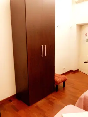 a large wooden cabinet and a chair in a room at affittacamere sereno in Rome
