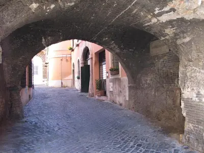 an alley in an old town with an archway at Guest House Arco Dei Tolomei in Rome