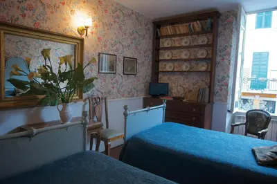 a bedroom with two beds and a desk and a window at Guest House Arco Dei Tolomei in Rome