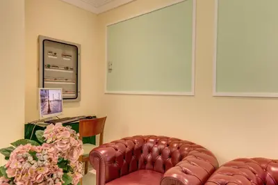 a living room with a leather couch and flowers at Hotel Igea in Rome