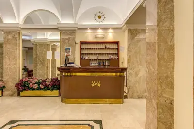 a hotel lobby with a reception desk and flowers at Hotel Igea in Rome