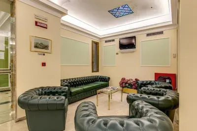 a waiting room with leather couches and a tv at Hotel Igea in Rome