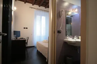 a bathroom with a sink and a bed in a room at House Monti 1875 in Rome