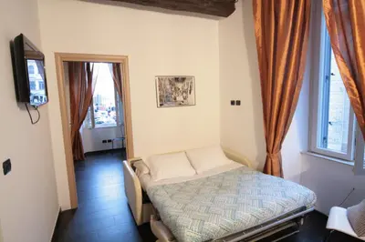 a bedroom with a bed in a room with windows at House Monti 1875 in Rome