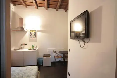 a room with a television on a wall with a table at House Monti 1875 in Rome