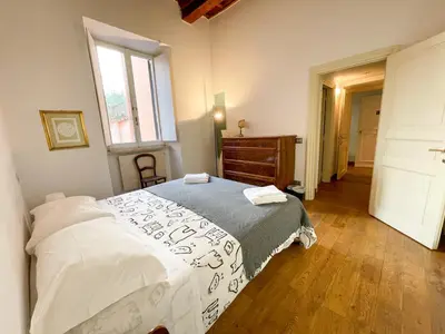 a bedroom with a bed and a dresser and a window at La Pigna Boutique Apartment in Rome