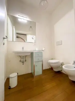 a bathroom with a sink and a toilet and a mirror at La Pigna Boutique Apartment in Rome