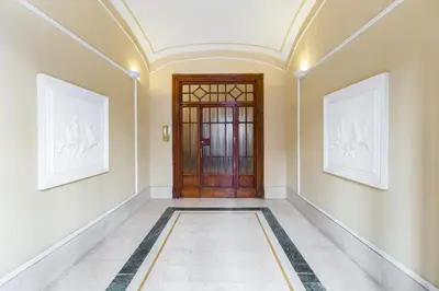 a hallway with a door and paintings on the walls at Elegant Apartment Rome in Rome