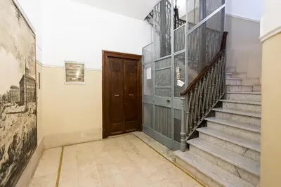 a hallway with stairs and a wooden door at Elegant Apartment Rome in Rome