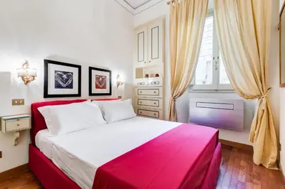 a bedroom with a red and white bed and a window at Elegant Apartment Rome in Rome