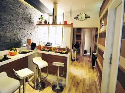 a kitchen with a counter and stools in a room at Living in Rome