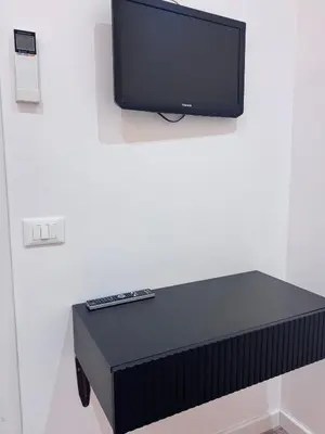 a tv sitting on top of a table with a remote control at Living in Rome