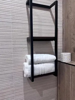 a towel rack with white towels in a bathroom at Living in Rome