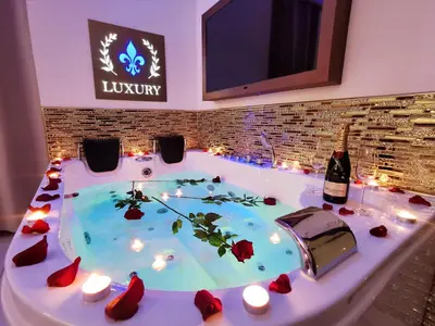 a hot tub with candles and a bottle of wine at Giglio Luxury Apartment - Romantic Jacuzzi in Rome