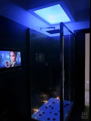 a bathroom with a shower and a tv in a room at Giglio Luxury Apartment - Romantic Jacuzzi in Rome