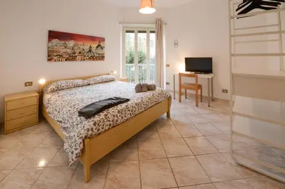 a bedroom with a bed and a desk and a television at GiuMa Roma Vatican Apartment in Rome