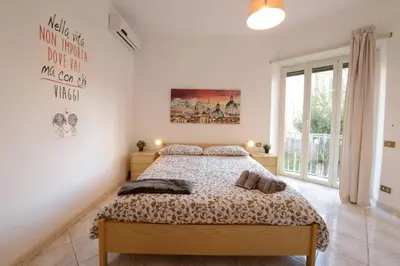 a bedroom with a bed and a large window at GiuMa Roma Vatican Apartment in Rome