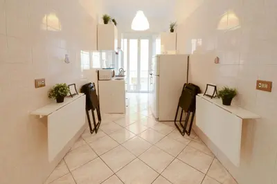 a room with two tables and a refrigerator at GiuMa Roma Vatican Apartment in Rome