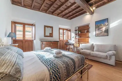 a bedroom with a large bed and a couch at GuestHost - Montecitorio & Pantheon Stylish Flat in Rome