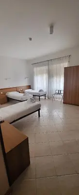 a large room with two beds in it at La Casa di Nazareth in Rome