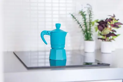 a blue water pitcher sitting on a counter with flowers at Urbana Coliseum House in Rome