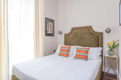 a bed with orange and white pillows on it at Daplace - Arena House in Rome