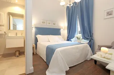 a bedroom with a blue and white bed and a mirror at Daplace - Arena House in Rome