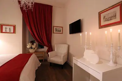 a bedroom with a bed and a chair and candles at Daplace - Arena House in Rome