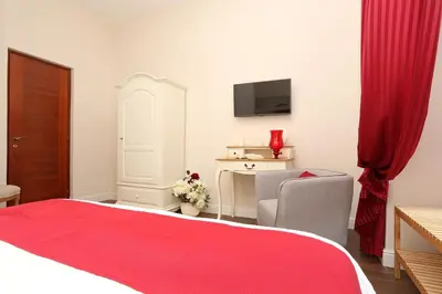 a bedroom with a red bed and a chair and a tv at Daplace - Arena House in Rome
