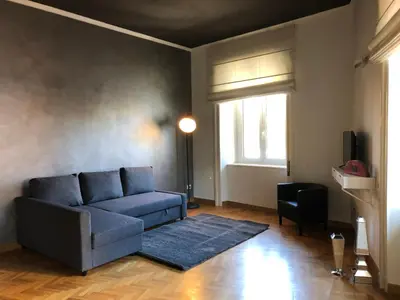 a living room with a blue couch and a window at Una finestra su Castel Sant'Angelo in Rome