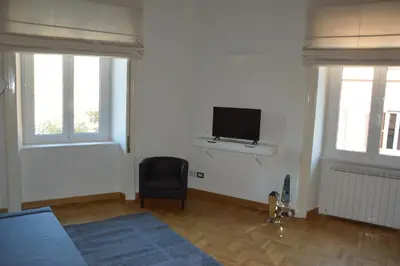 a bedroom with a tv and a chair in a room at Una finestra su Castel Sant'Angelo in Rome